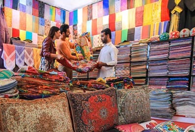 Visitors exploring a textile market with colourful fabric displays in Dubai
