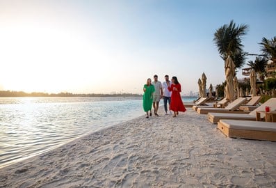Group of four people walking along the beach