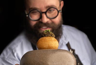 Chef at Orfali Bros Bistro proudly presenting a newly created signature dish