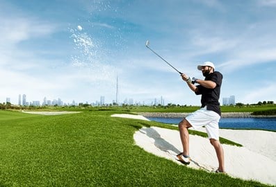 Man playing golf in Dubai with the Burj Khalifa in the background