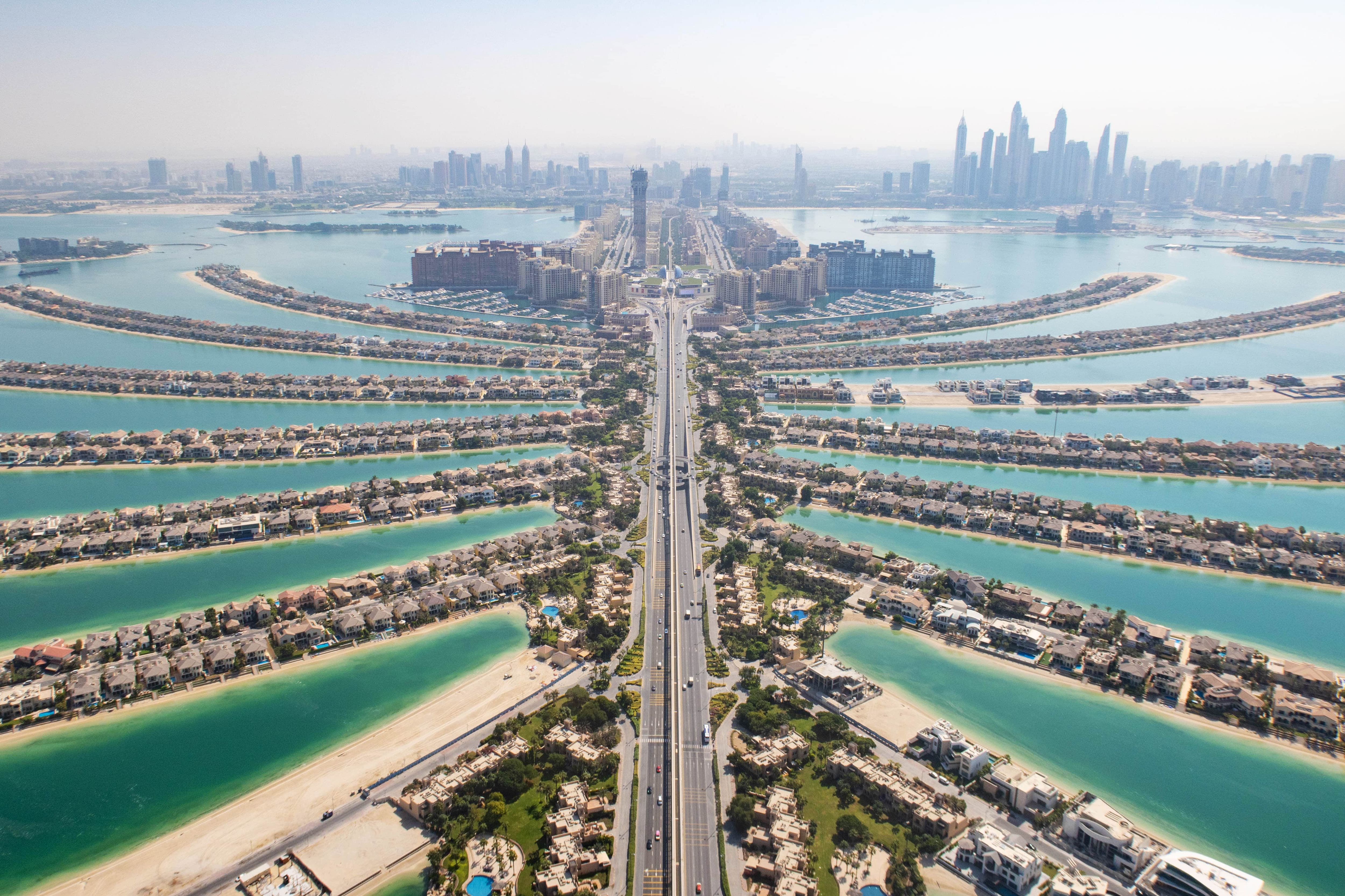 Aerial view of the fronds and villas of Palm Jumeirah with the Dubai Marina skyline beyond