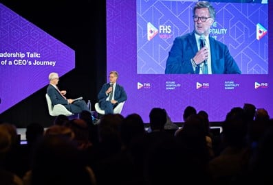 Speaker presenting on stage to an audience at a hospitality industry event in Dubai
