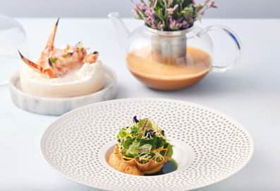 Premium seafood courses and a microgreen salad tartlet elegantly presented at Al Muntaha