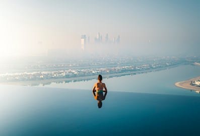 woman in swimming pool looking at the palm view