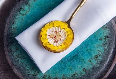 Artistically plated vegetarian fine dining course on a gold spoon at Avatara restaurant