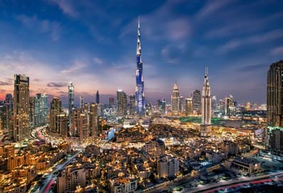 Aerial view of Dubai's majestic skyline at night with Burj Khalifa at its centre.