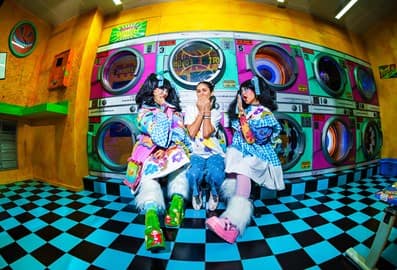 Three people posing in a colorful immersive room at House of Hype Dubai.