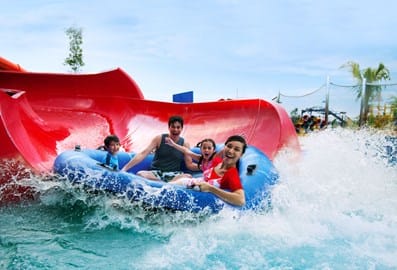 A group of young kids sliding down a waterslide at Legoland Waterpark Dubai.