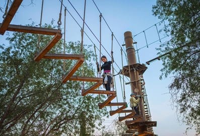 Woman on a high ropes course at Mushrif National Park Dubai
