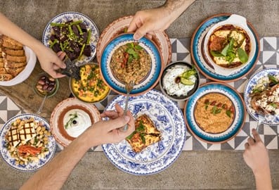 Traditional Greek shared plates and mezze spread at Mythos Kouzina & Grill restaurant