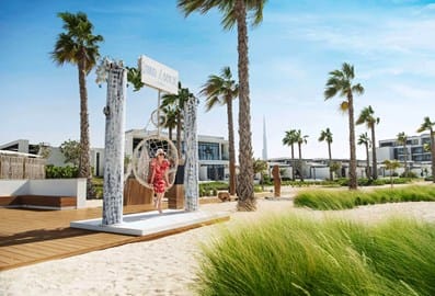 Visitor posing on a swing at the Nikki Beach Dubai entrance