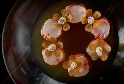 Fine dining gourmet dish with floral arrangements at Row on 45