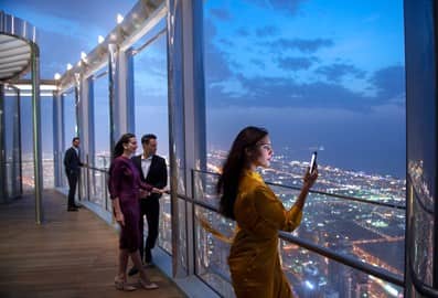 Visitors enjoying panoramic nighttime views of Dubai’s illuminated skyline