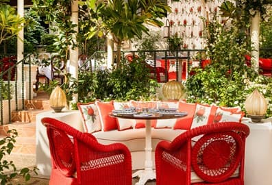 The garden-style outdoor dining patio at Gloria Osteria restaurant in Dubai