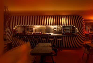 The striking, striped open kitchen and bar counter at Yaba restaurant