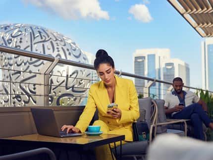 25 Hour Hotel outdoor view of Museum of the future | Female investors working on the laptop