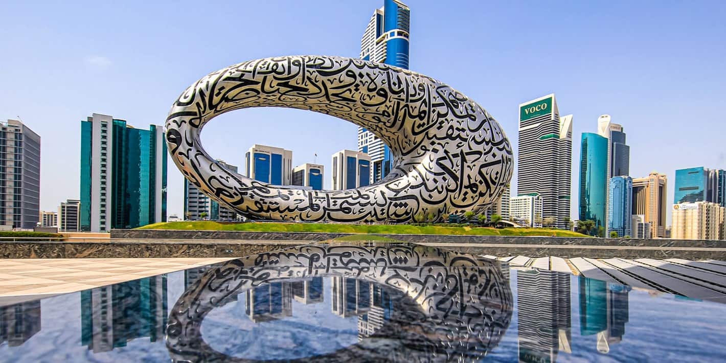 Exterior view of the Museum of the Future in Dubai with the city skyline in the background.