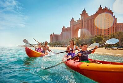 Family kayaking next to Atlantis Dubai