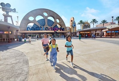 Children running in front of the Motiongate Dubai entrance at Dubai Parks and Resorts