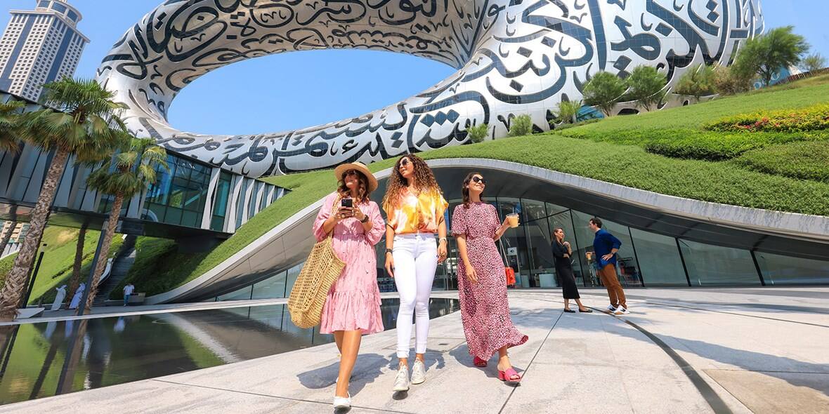 women standing in front of museum of the future