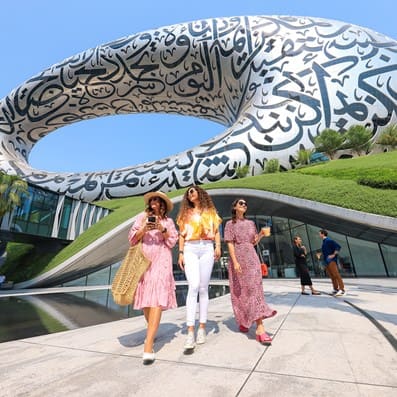 women standing in front of museum of the future