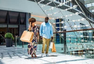 Couple walking with shopping bags in a mall in Dubai