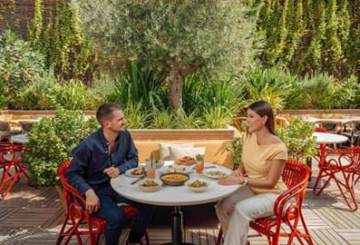 A couple enjoying alfresco dining at a garden terrace restaurant in Dubai