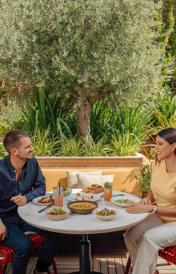 A couple enjoying alfresco dining at a garden terrace restaurant in Dubai