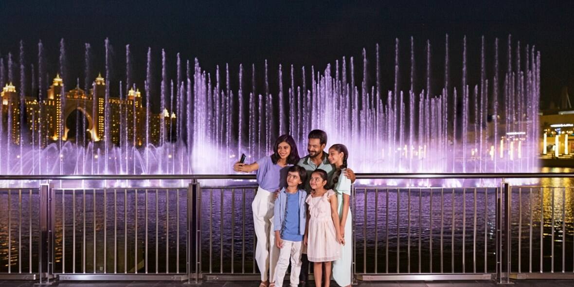 Family pose for selfie at The Pointe fountain show