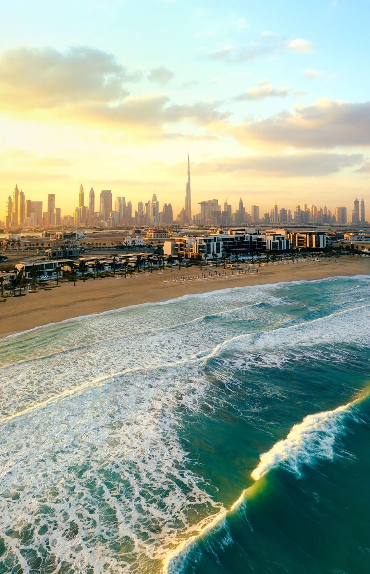 View of Dubai's skyline from the seaside at sunrise.