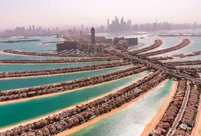 An areal view of Palm Jumeirah branches from the north side, with the mainland in the background and skyscrappers of Dubai Marina