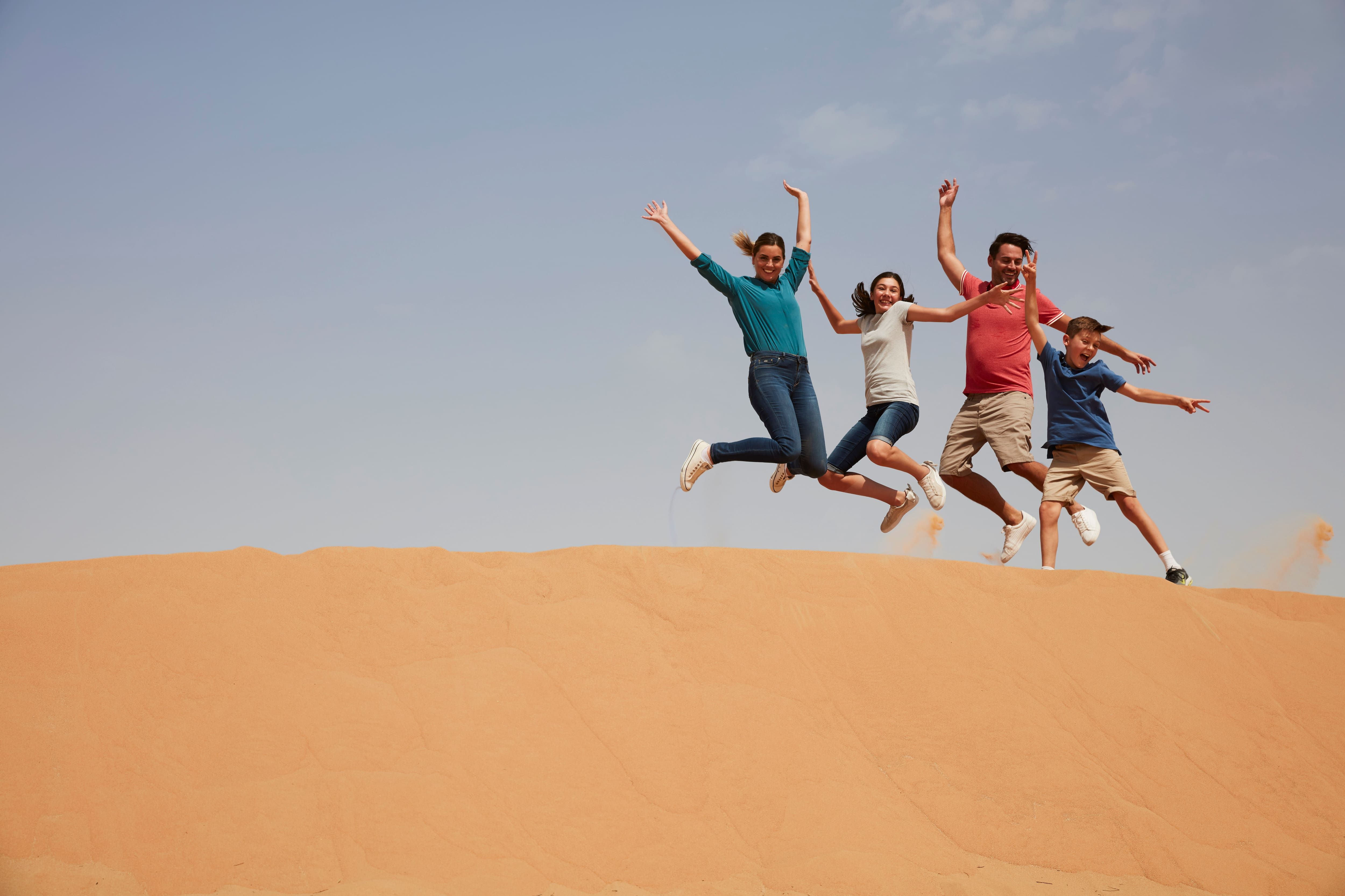 Family jumping on desert in Dubai